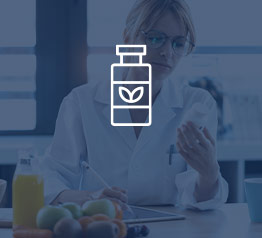 Woman in lab coat holding a pill bottle working on a tablet with Sage X3 ERP software for nutraceuticals